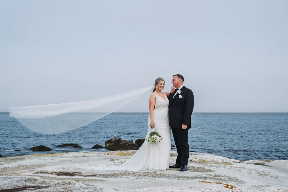 Bride and groom standing on a rock at Port Mouton wedding.