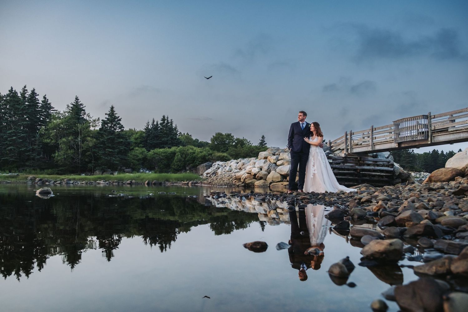 Bride and groom standing by the water at White Point Beach Resort Wedding.