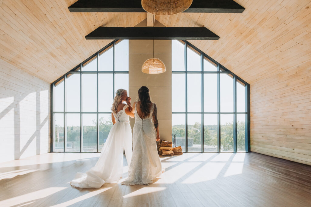 Two brides share a sweet moment in the common room at The Farm at South Cove. 